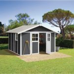 Vue extérieure de l'abri PVC gris foncé posé dans un jardin avec porte fermée