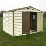 Abri PVC en situation de jardin avec mobilier rangé devant