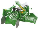 Machine en action sur un champ déposant les tubercules latéralement