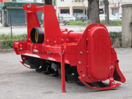 Vue de face de la fraise rotative montée sur un tracteur avec carter visible