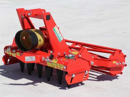 Vue de face de la herse rotative montée sur sol agricole