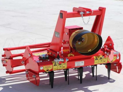Herse montée sur un tracteur montrant les lames et le rouleau de rappuyage en champ